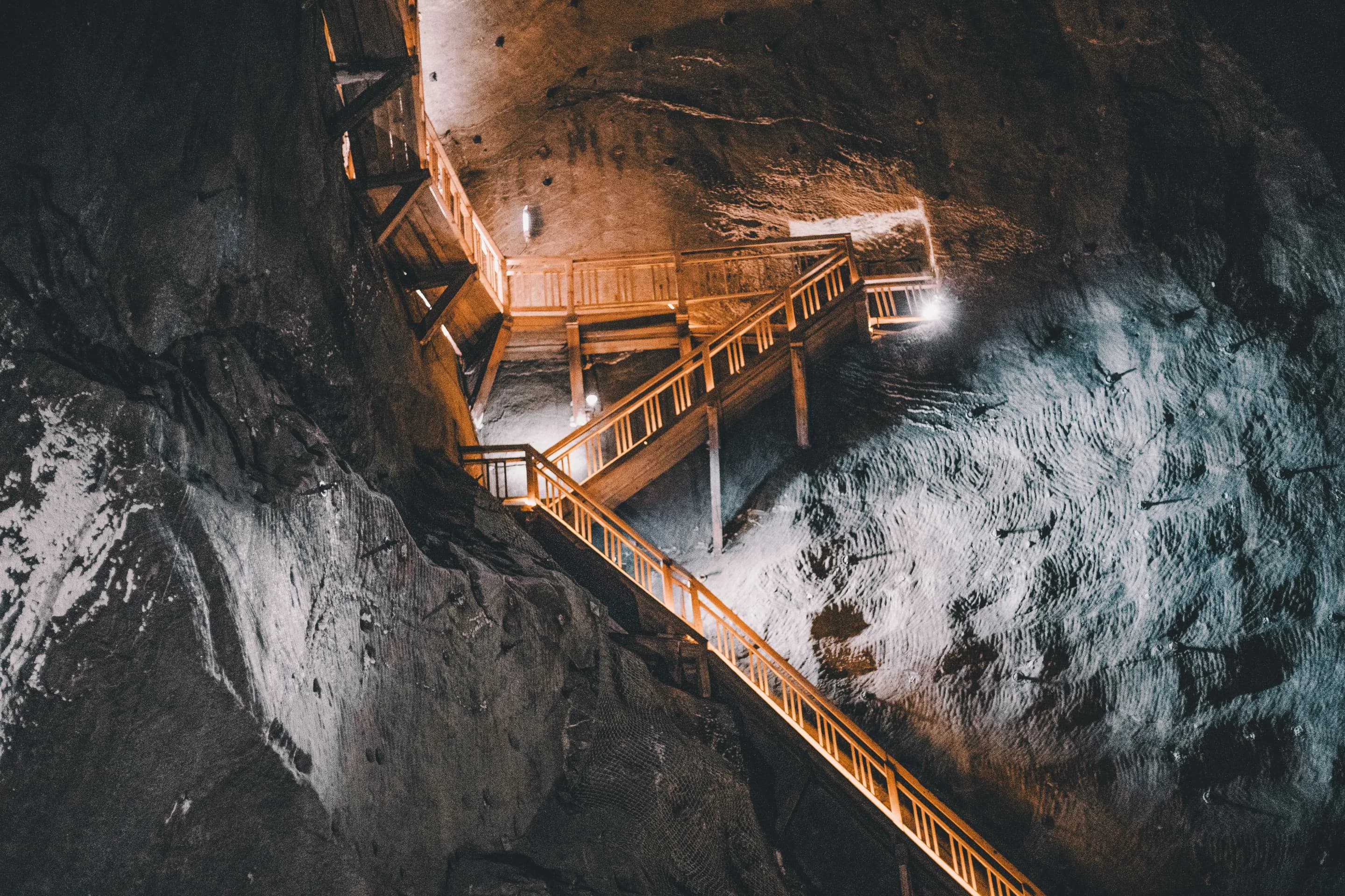 Illuminated access stairs descending through an underground mine.